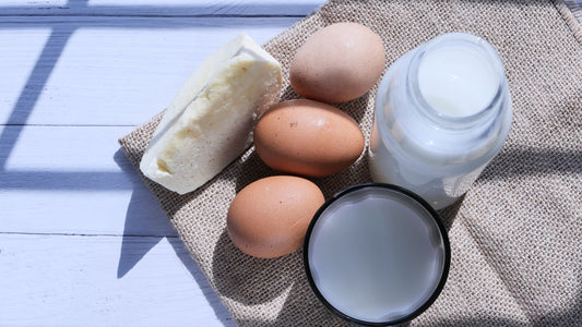 Eggs, milk and cheese arranged on a table.
