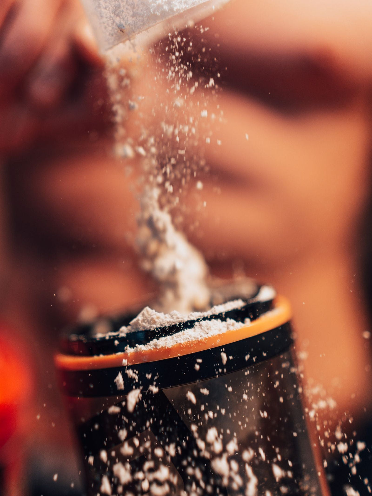Powder being poured into a shaker bottle.