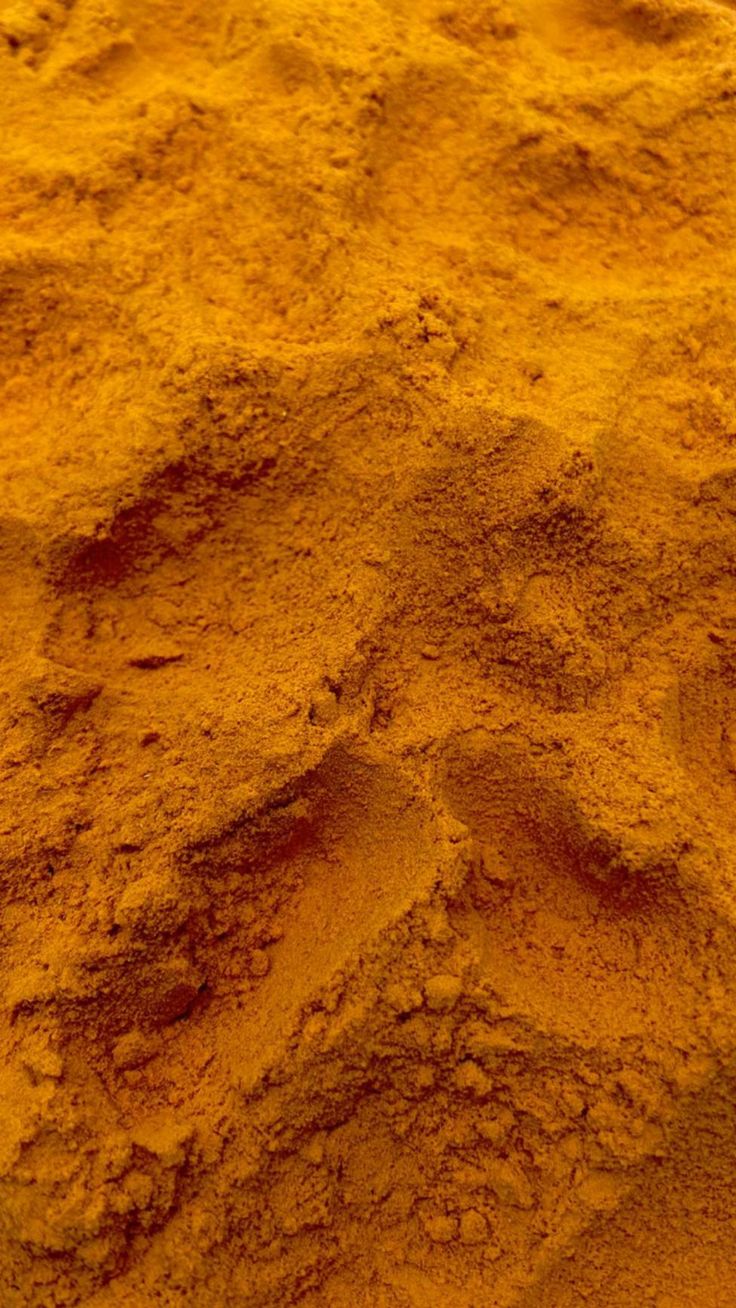 Close-up texture of orange turmeric powder.